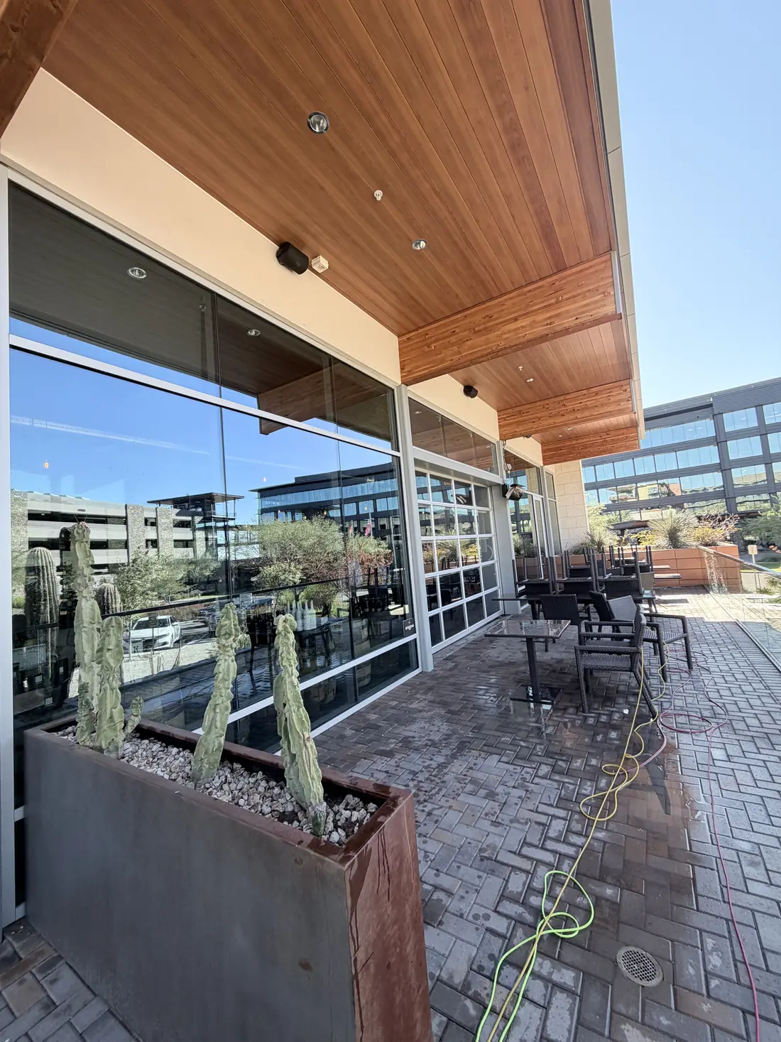 Clean commercial patio with glass railings and paver flooring after service
